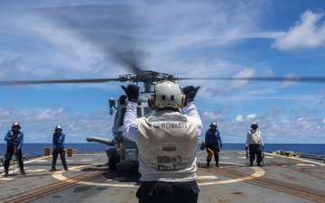 Sailors aboard the USS Howard conduct flight quarters with an MH-60R Sea Hawk helicopter as part of an exercise with the HMAS Sydney V in the South China Sea