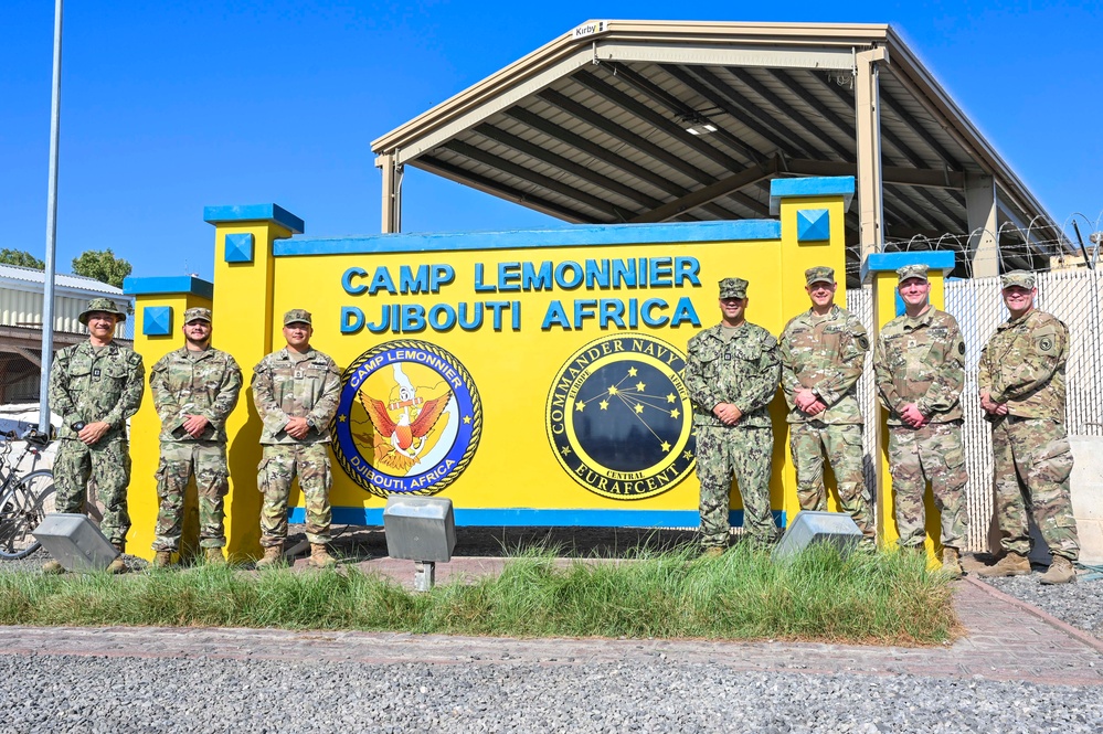 U.S. service members pose in front of Camp Lemonnier sign