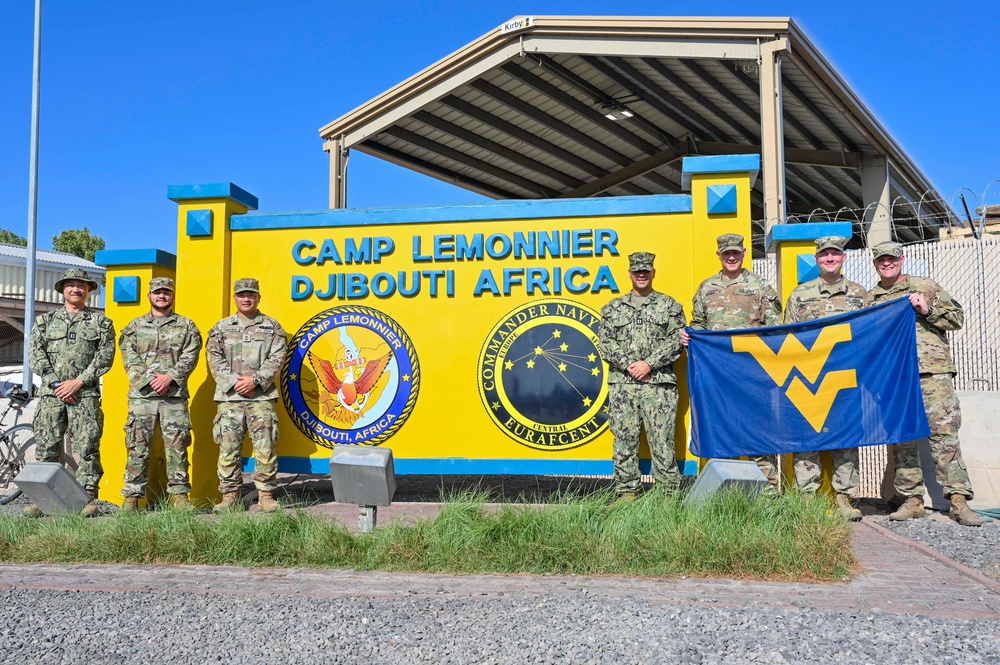 U.S. service members pose for a group photo at the Camp Lemonnier sign