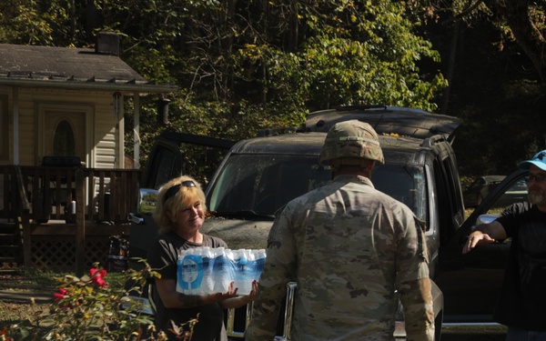 U.S. Army Soldiers, in support of FEMA during Hurricane Helene, deliver food, and water to civilians in need