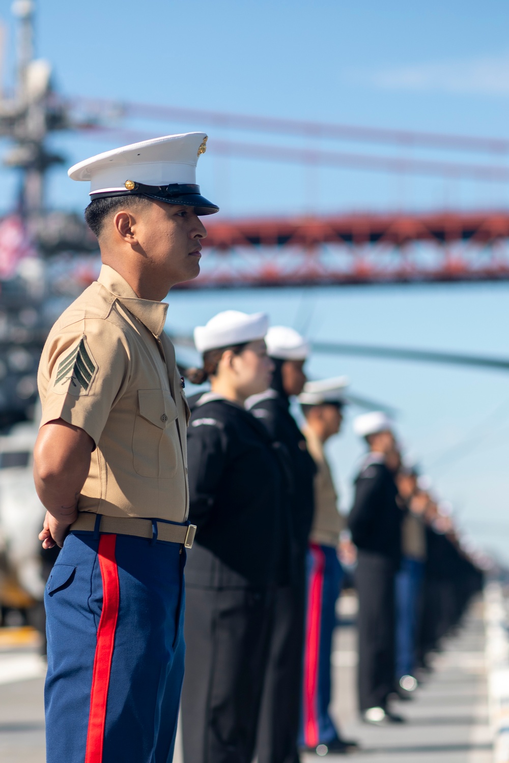 USS Tripoli Sailors man the rails while pulling into San Francisco