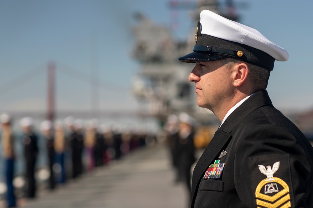 USS Tripoli Sailors man the rails while pulling into San Francisco