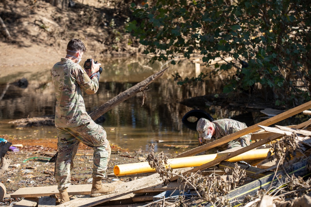 Tennessee National Guard public affairs specialist documents soil collection after Hurricane Helene