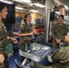 Military personnel from participating nations attend a medical presentation aboard the USS Howard during Sama Sama 2024