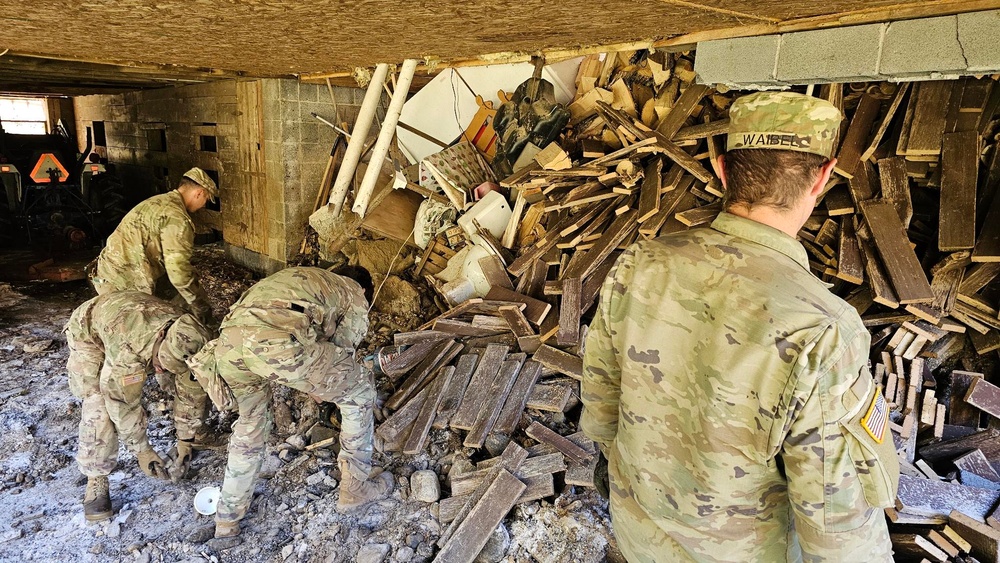 Screaming Eagles fix a fence and remove wreckage for a local citizen