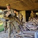 Screaming Eagles fix a fence and remove wreckage for a local citizen