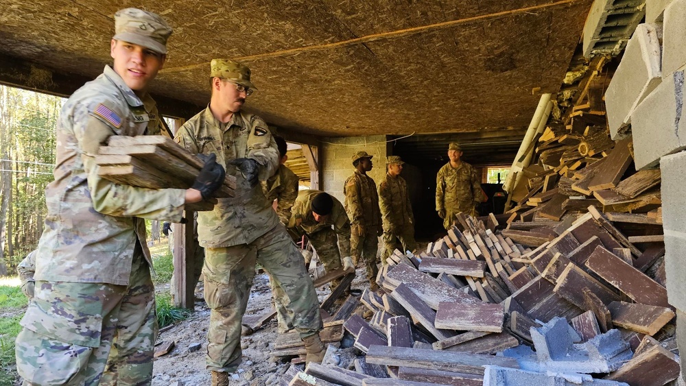 Screaming Eagles fix a fence and remove wreckage for a local citizen