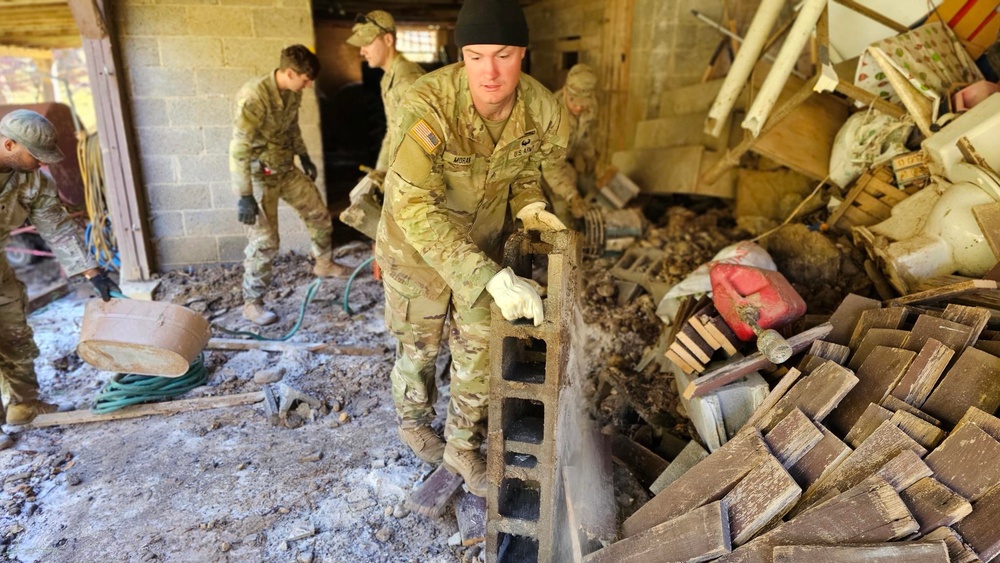 Screaming Eagles fix a fence and remove wreckage for a local citizen