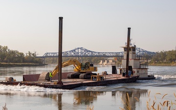 USACE heavy equipment operator scoops riprap along Missouri River