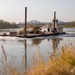 USACE heavy equipment operator scoops riprap along Missouri River