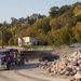 USACE heavy equipment operator scoops riprap along Missouri River