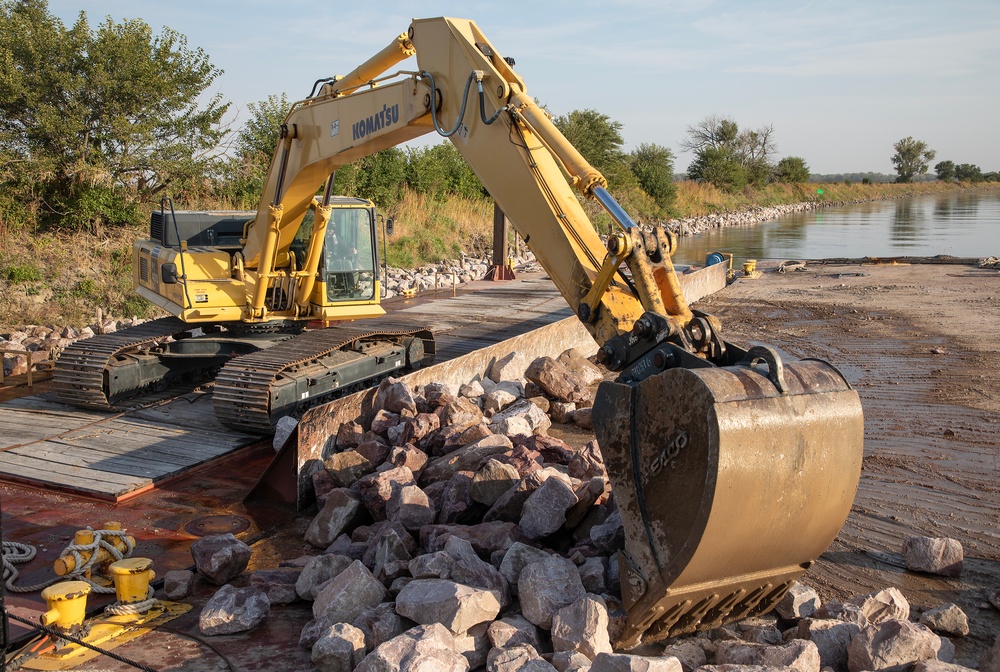 USACE heavy equipment operator scoops riprap along Missouri River