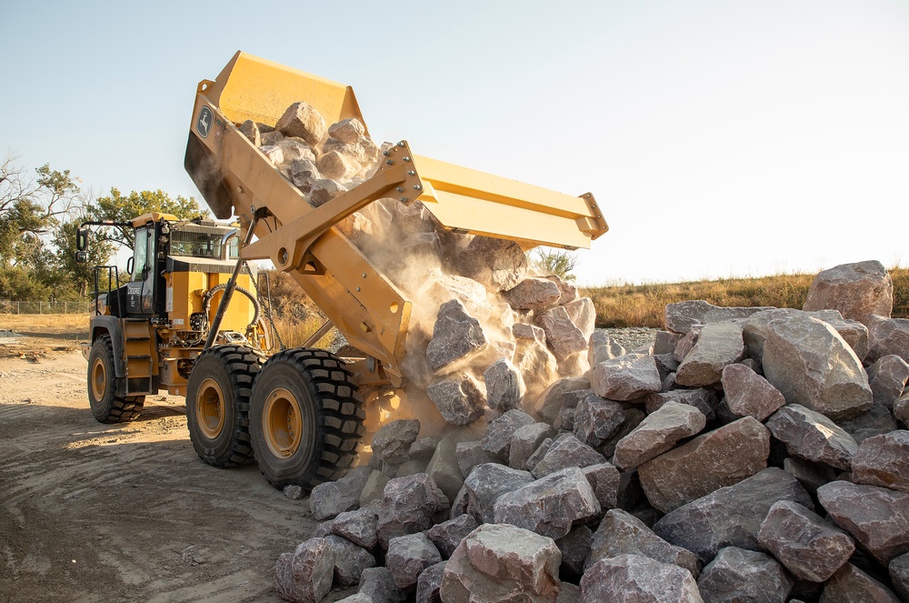 USACE heavy equipment operator scoops riprap along Missouri River