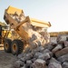 USACE heavy equipment operator scoops riprap along Missouri River