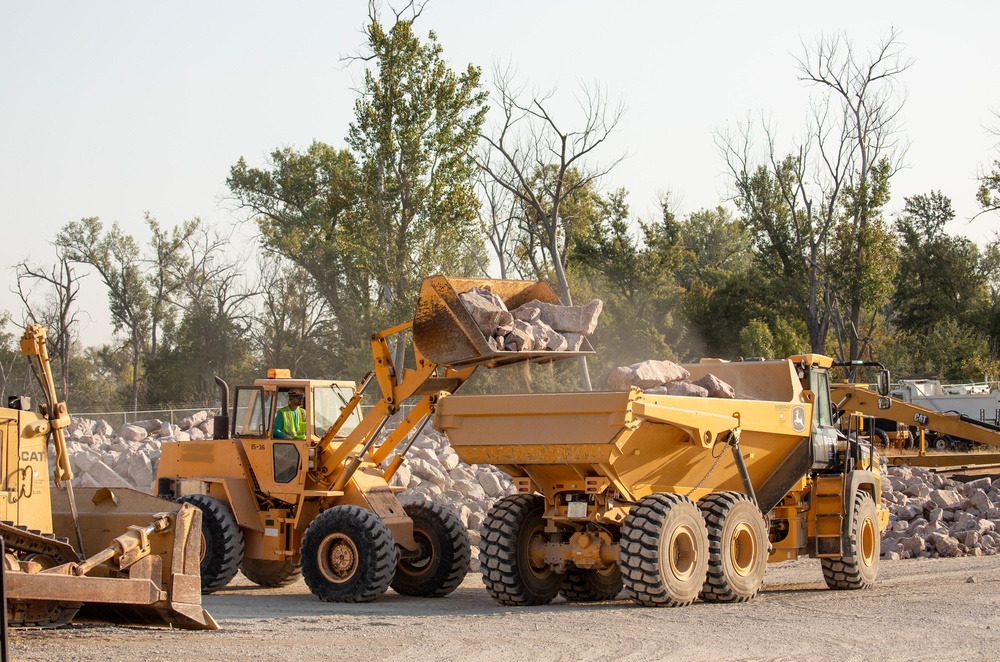 USACE heavy equipment operator scoops riprap along Missouri River