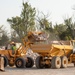 USACE heavy equipment operator scoops riprap along Missouri River