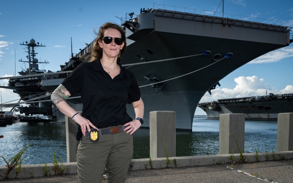 Naval Criminal Investigative Service (NCIS) Special Agent Afloat (SAA) Bernadette Fuffy poses for an environmental portrait in front of the US Navy aircraft carrier USS Harry S. Truman (CVN 75) at Norfolk Naval Station Virginia on 19 September 2024.