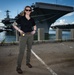 Naval Criminal Investigative Service (NCIS) Special Agent Afloat (SAA) Bernadette Fuffy poses for an environmental portrait in front of the US Navy aircraft carrier USS Harry S. Truman (CVN 75) at Norfolk Naval Station Virginia on 19 September 2024.