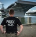 Naval Criminal Investigative Service (NCIS) Special Agent Afloat (SAA) Justin Botkin stand for an environmental portrait in front of the US Navy aircraft carrier USS Harry S. Truman (CVN 75) at Norfolk Naval Station Virginia on 19 September 2024.