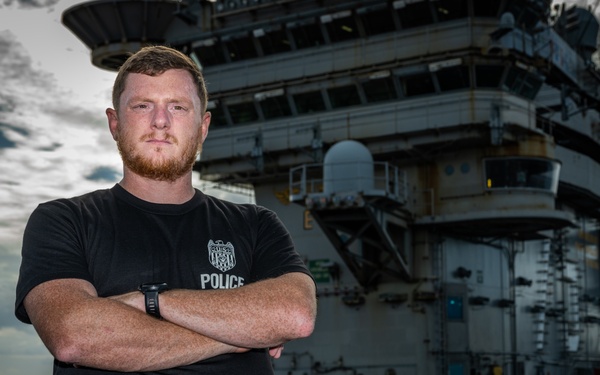 Naval Criminal Investigative Service (NCIS) Special Agent Afloat (SAA) Justin Botkin stand for an environmental portrait on the flight deck of the aircraft carrier USS Harry S. Truman (CVN 75) at Norfolk Naval Station Virginia on 19 September 2024.