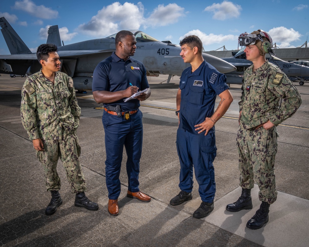 Naval Criminal Investigative Service (NCIS) Special Agent (SA) Kenneth Randle interviewing Aviation Electronics Technician (ATAN) Juan Lamas; ATAN Lucas Di Giacomo and Aviation Ordnancemen First Class (AO1) Jason Spire about an on-going investigation