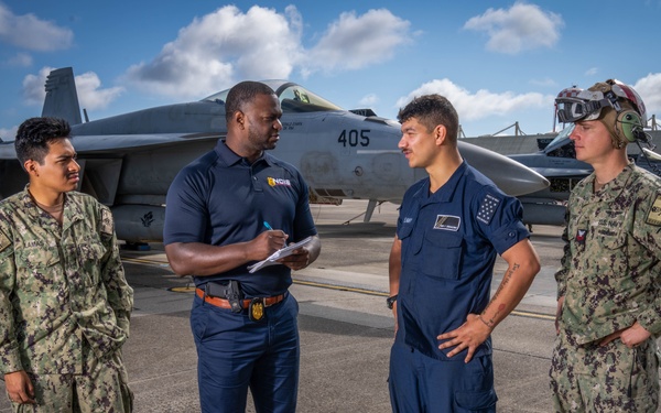 Naval Criminal Investigative Service (NCIS) Special Agent (SA) Kenneth Randle interviewing Aviation Electronics Technician (ATAN) Juan Lamas; ATAN Lucas Di Giacomo and Aviation Ordnancemen First Class (AO1) Jason Spire about an on-going investigation