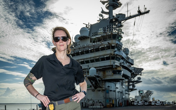 Naval Criminal Investigative Service (NCIS) Special Agent Afloat (SAA) Bernadette Duffy poses for an environmental portrait on the flight deck of the US Navy aircraft carrier USS Harry S. Truman (CVN 75)