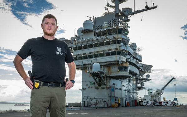 Naval Criminal Investigative Service (NCIS) Special Agent Afloat (SAA) Justin Botkin stand for an environmental portrait on the flight deck of the aircraft carrier USS Harry S. Truman (CVN 75)