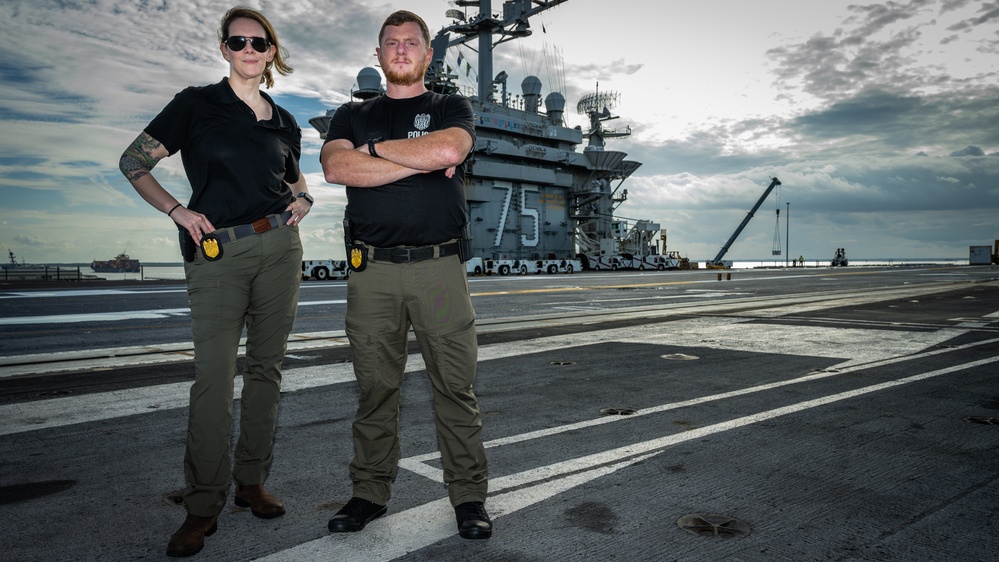 Naval Criminal Investigative Service (NCIS) Special Agents Afloat (SAA) Bernadette Duffy and Justin Botkin stand for an environmental portrait on the flight deck of the aircraft carrier USS Harry S. Truman (CVN 75)