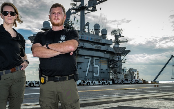 Naval Criminal Investigative Service (NCIS) Special Agents Afloat (SAA) Bernadette Duffy and Justin Botkin stand for an environmental portrait on the flight deck of the aircraft carrier USS Harry S. Truman (CVN 75)