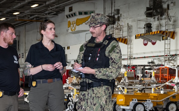 Naval Criminal Investigative Service (NCIS) Special Agents Afloat (SAA) Bernadette Duffy and Justin Botkin talk with Master-at-Arms First Class (MA!) Travis Beckman about an on-going investigation