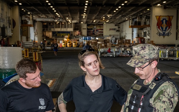 Naval Criminal Investigative Service (NCIS) Special Agents Afloat (SAA) Bernadette Duffy and Justin Botkin talk with Master-at-Arms First Class (MA!) Travis Beckman about an on-going investigation