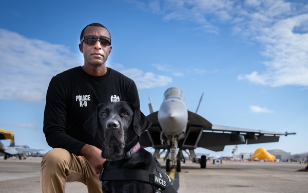 Naval Criminal Investigative Service (NCIS) Special Agent (SA) David Lawhorn and his K-9 companion Jill around the flight line with F-18 Hornets and the U. S. Navy's Flight Demonstration Team, Blue Angels