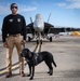 Naval Criminal Investigative Service (NCIS) Special Agent (SA) David Lawhorn and his K-9 companion Jill around the flight line with F-18 Hornets