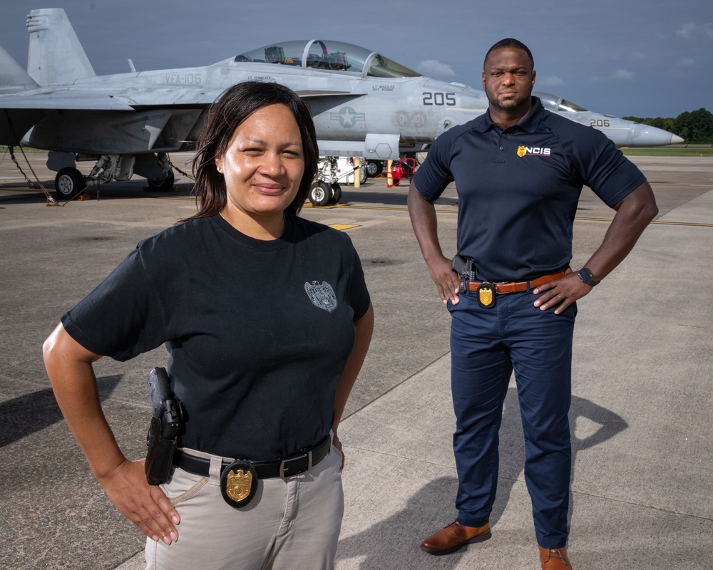 Naval Criminal Investigative Service (NCIS) Supervisory Special Agent (SSA) Jennifer Lynch and Special Agent (SA) Kenneth Randle around the flight line with F-18 Hornet