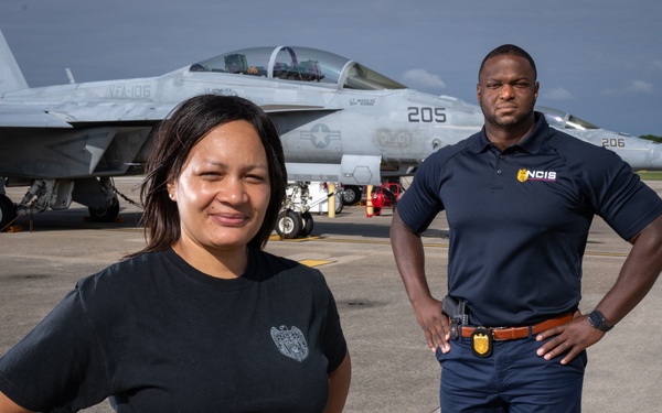 Naval Criminal Investigative Service (NCIS) Supervisory Special Agent (SSA) Jennifer Lynch and Special Agent (SA) Kenneth Randle around the flight line with F-18 Hornet