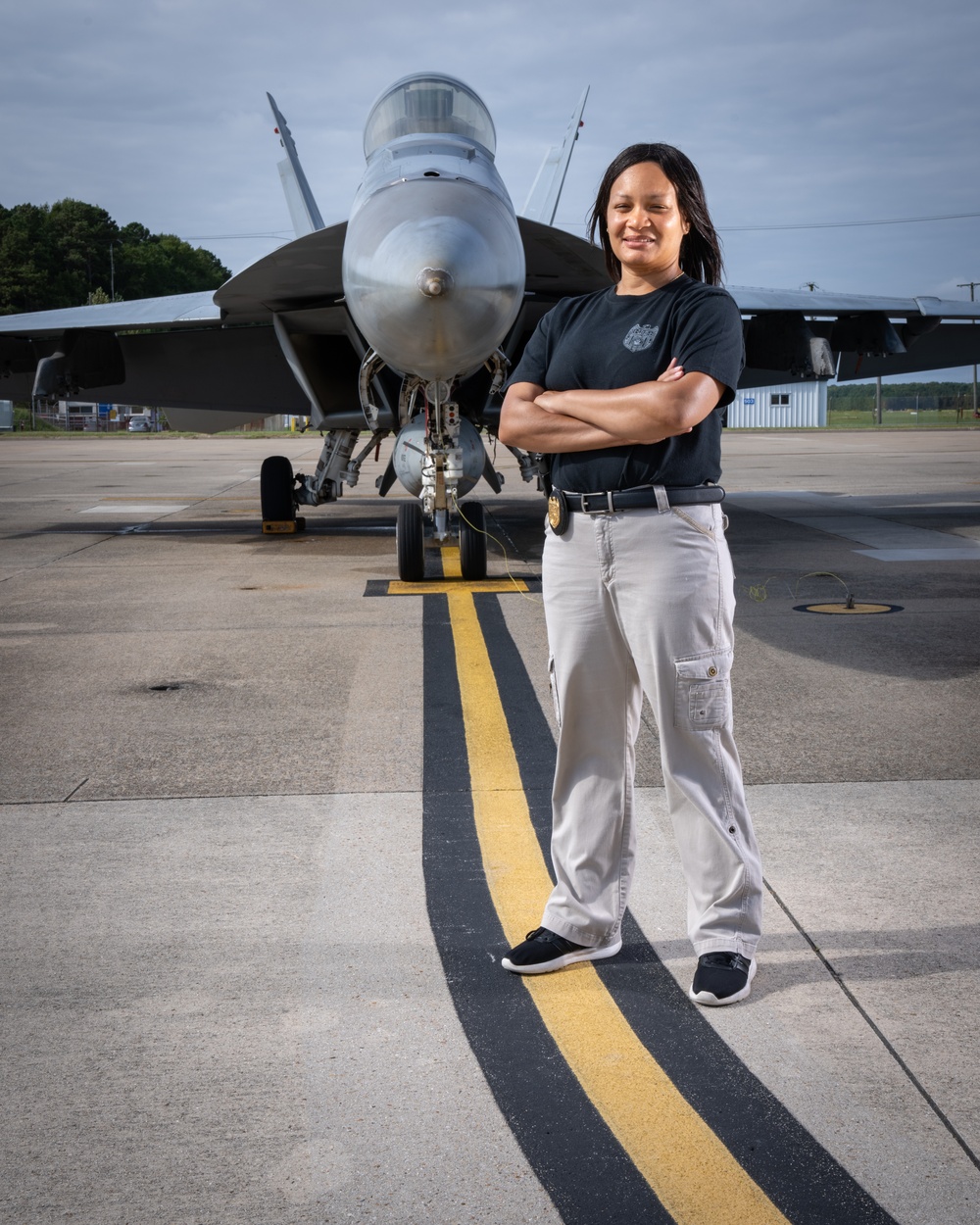 Naval Criminal Investigative Service (NCIS) Supervisory Special Agent (SSA) Jennifer Lynch around the flight line with F-18 Hornets