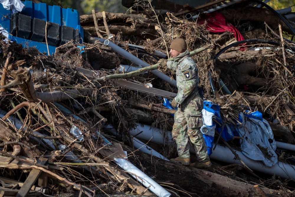 887th Engineer Company, 19th Engineer Battalion climbs on top of debris left behind by Hurricane Helene