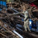 887th Engineer Company, 19th Engineer Battalion climbs on top of debris left behind by Hurricane Helene