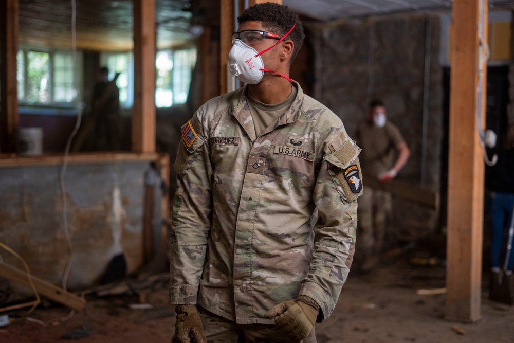 U.S. Army Private First Class Alexander Rodriguez assigned to Hardrock Company, 1-50 Infantry Regiment, 2nd Mobile Brigade Combat Team, 101st Airborne Division (Airborne), removes debris from a local business in Chimney Rock, North Carolina