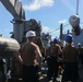 Sailors aboard the USS Howard conduct a torpedo download in the South China Sea