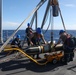 Sailors aboard the USS Howard conduct a torpedo download in the South China Sea