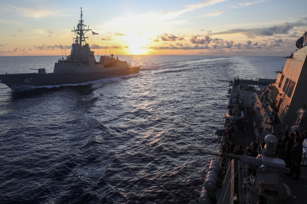 Sailors aboard the USS Howard wave farewell to the HMAS Sydney V in the South China Sea