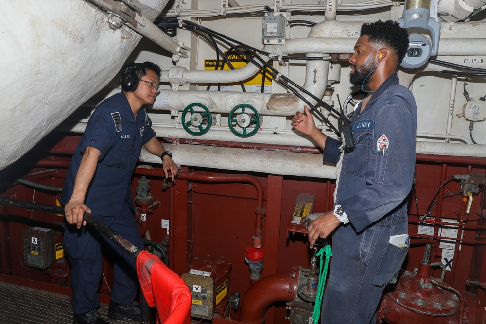 Sailors aboard the USS Howard conduct an engineering training team drill in the South China Sea