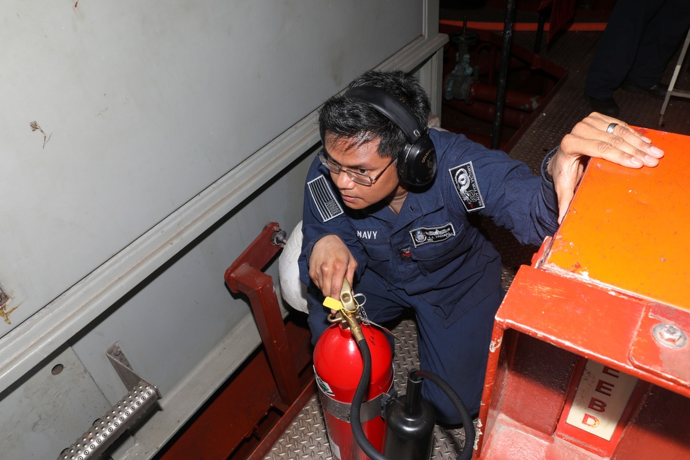 Sailors aboard the USS Howard conduct an engineering training team drill in the South China Sea