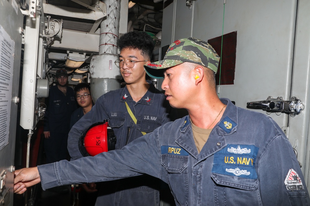 Sailors aboard the USS Howard conduct an engineering training team drill in the South China Sea