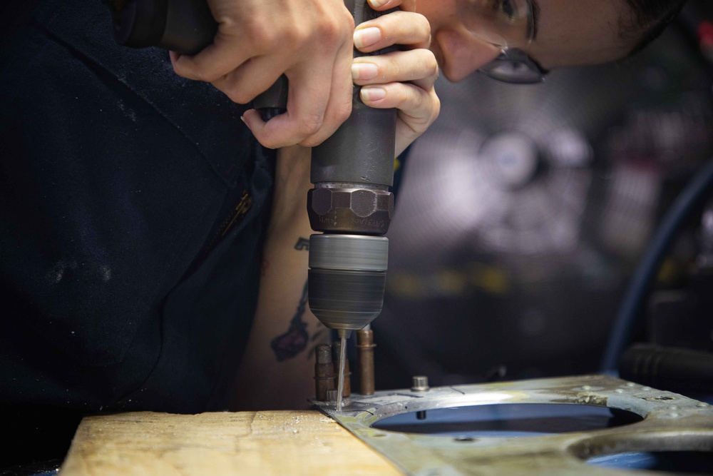 Sailors fabricate a metal patch aboard USS George Washington