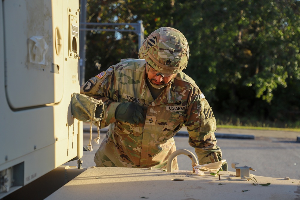 Sustainment Soldiers Conduct preventative maintenance check on M1087 Expandable Van Shelter