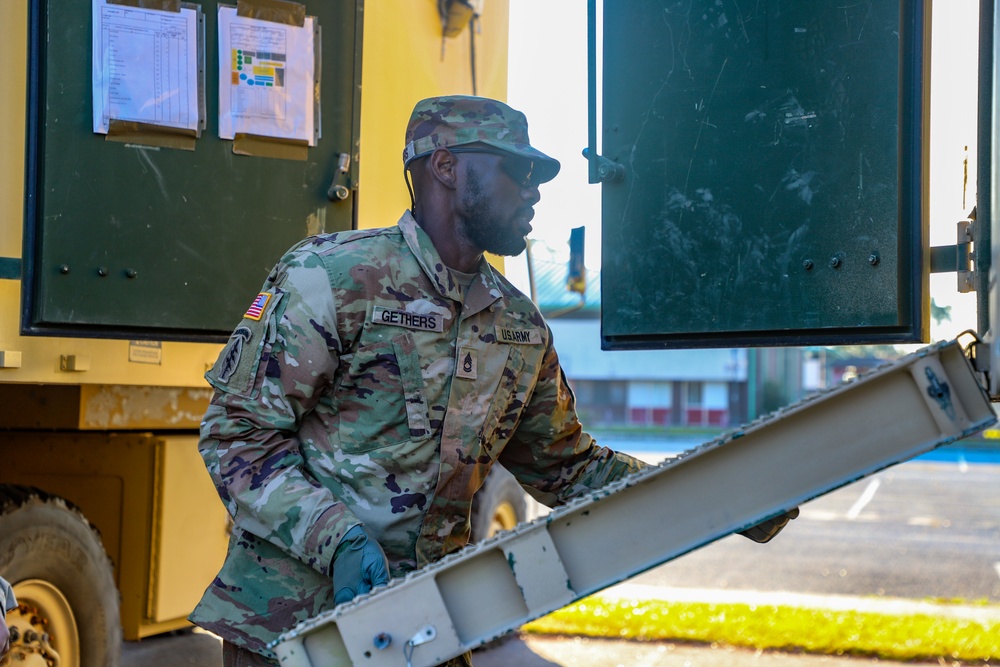 Sustainment Soldiers Conduct preventative maintenance check on M1087 Expandable Van Shelter