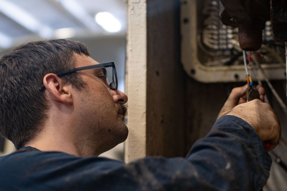 Weapons department Sailor replaces wiring insulation aboard USS George Washington